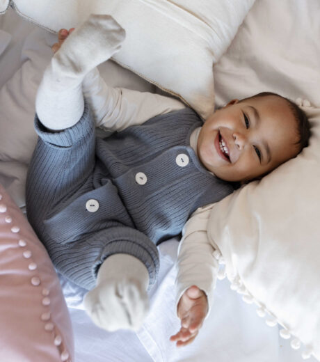 adorable-baby-laughing-laying-bed-(1)_optimized
